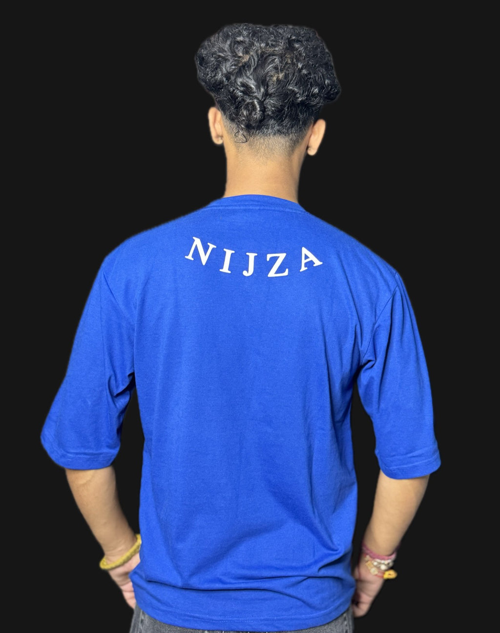 Person wearing a blue shirt with 'NIJZA' printed on the back against a black background