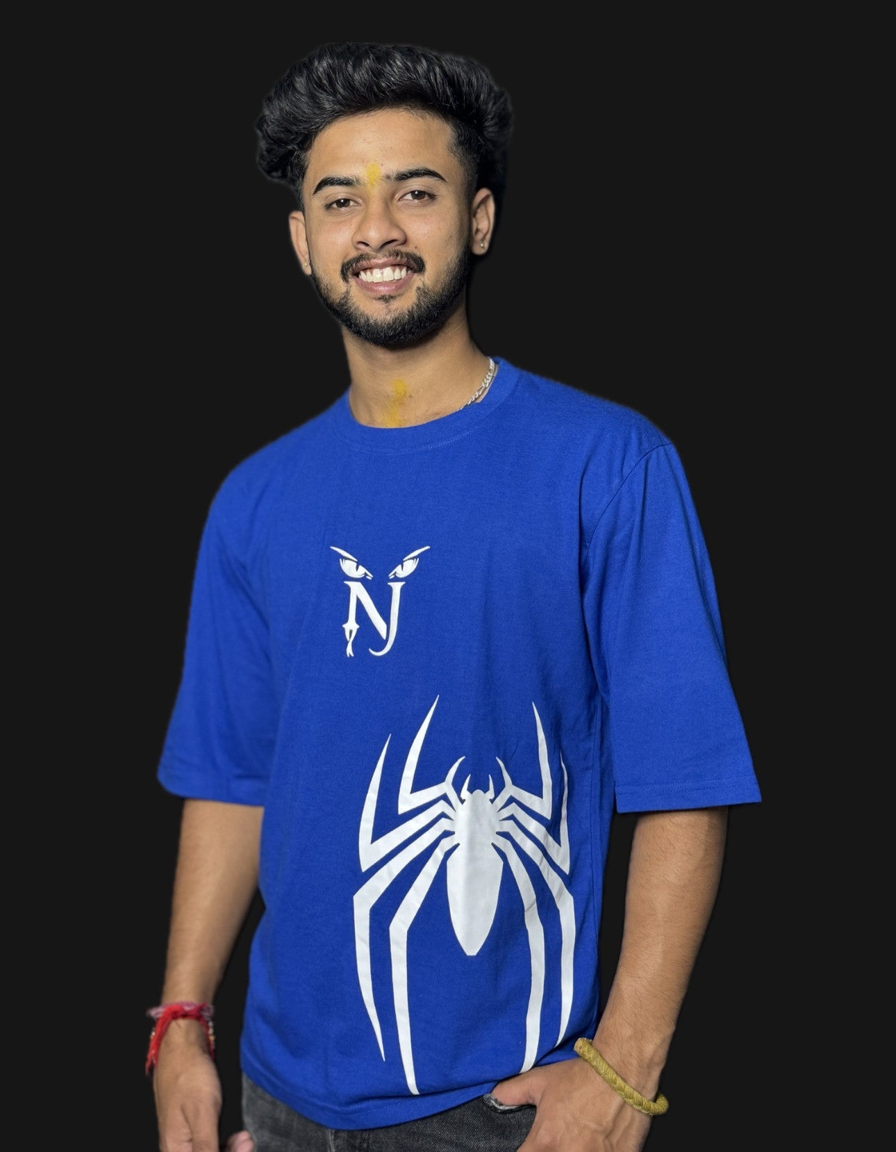 Person wearing a blue t-shirt with a white spider design on a black background