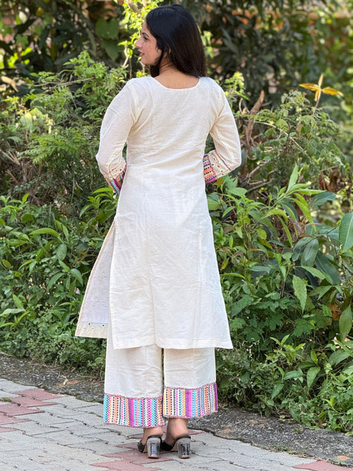 Woman in a white traditional outfit standing in a garden